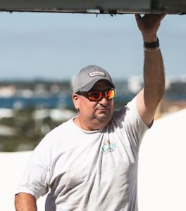 man guiding large ac unit as it's moved